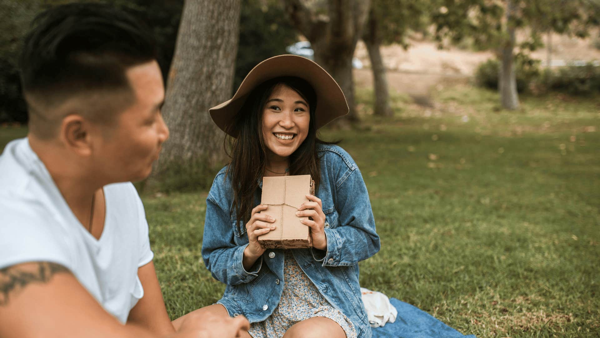 woman smiling with gift at man