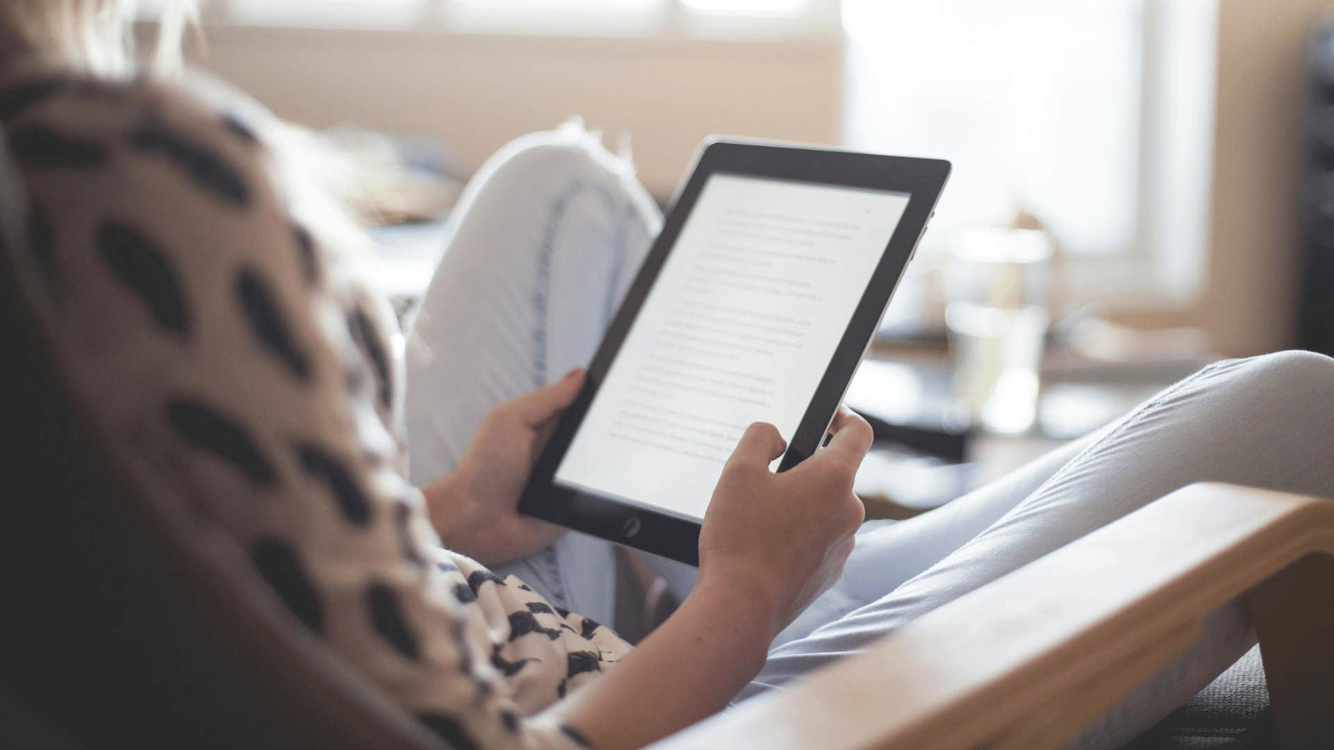 woman reading on electronic reader