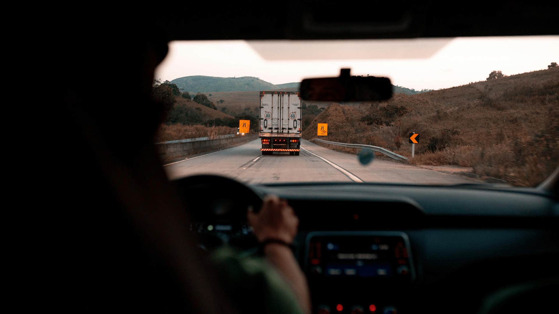 man driving behind semitruck