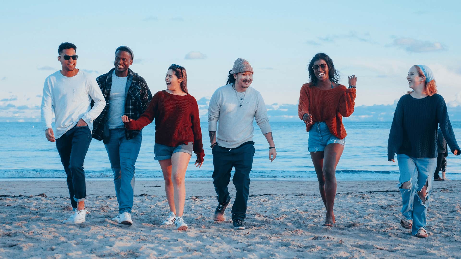 group of friends walking on beach