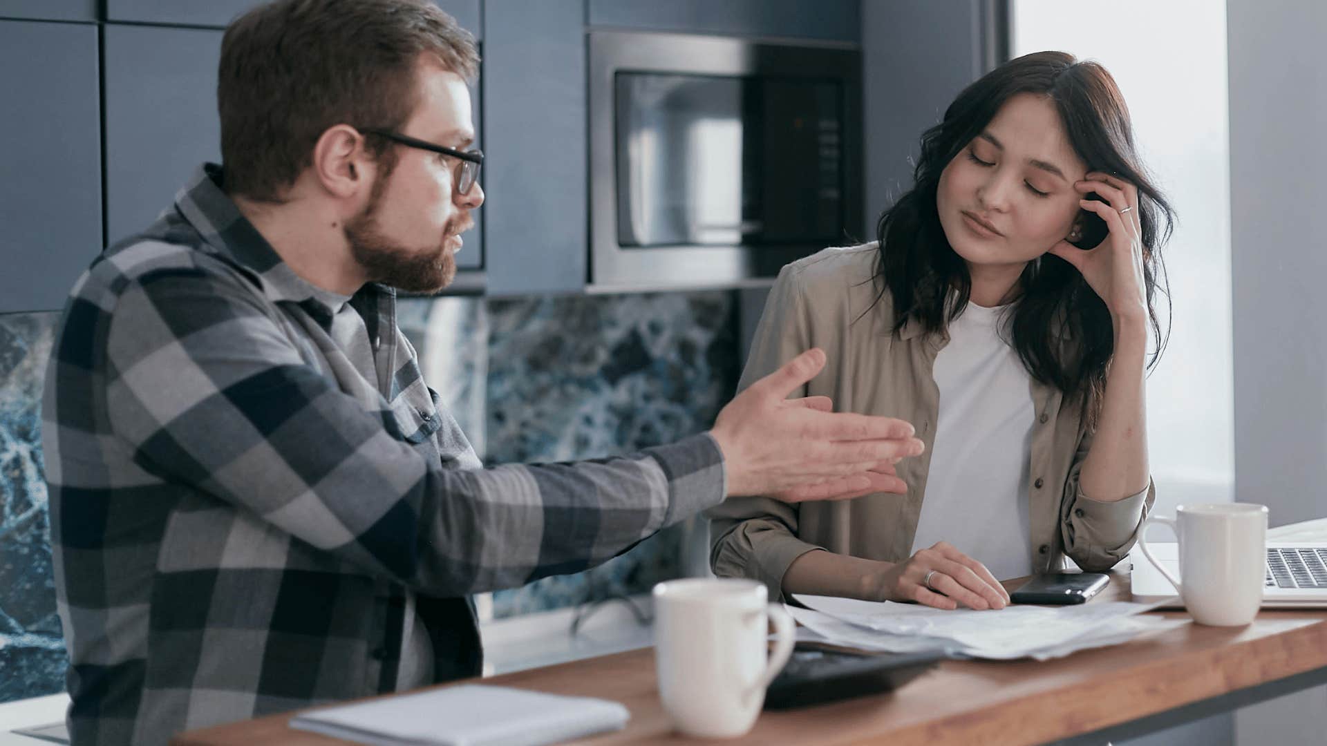 frustrated man speaking to woman with eyes closed