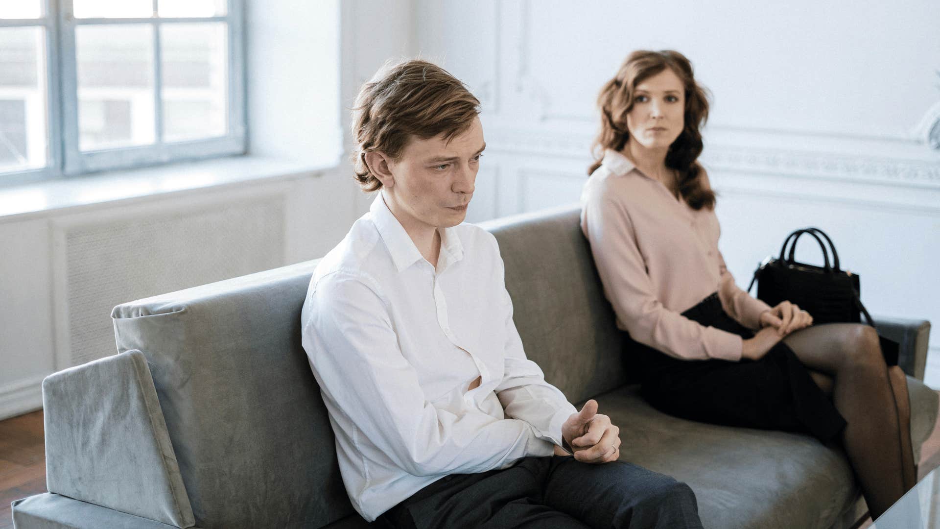 couple sitting far apart on couch