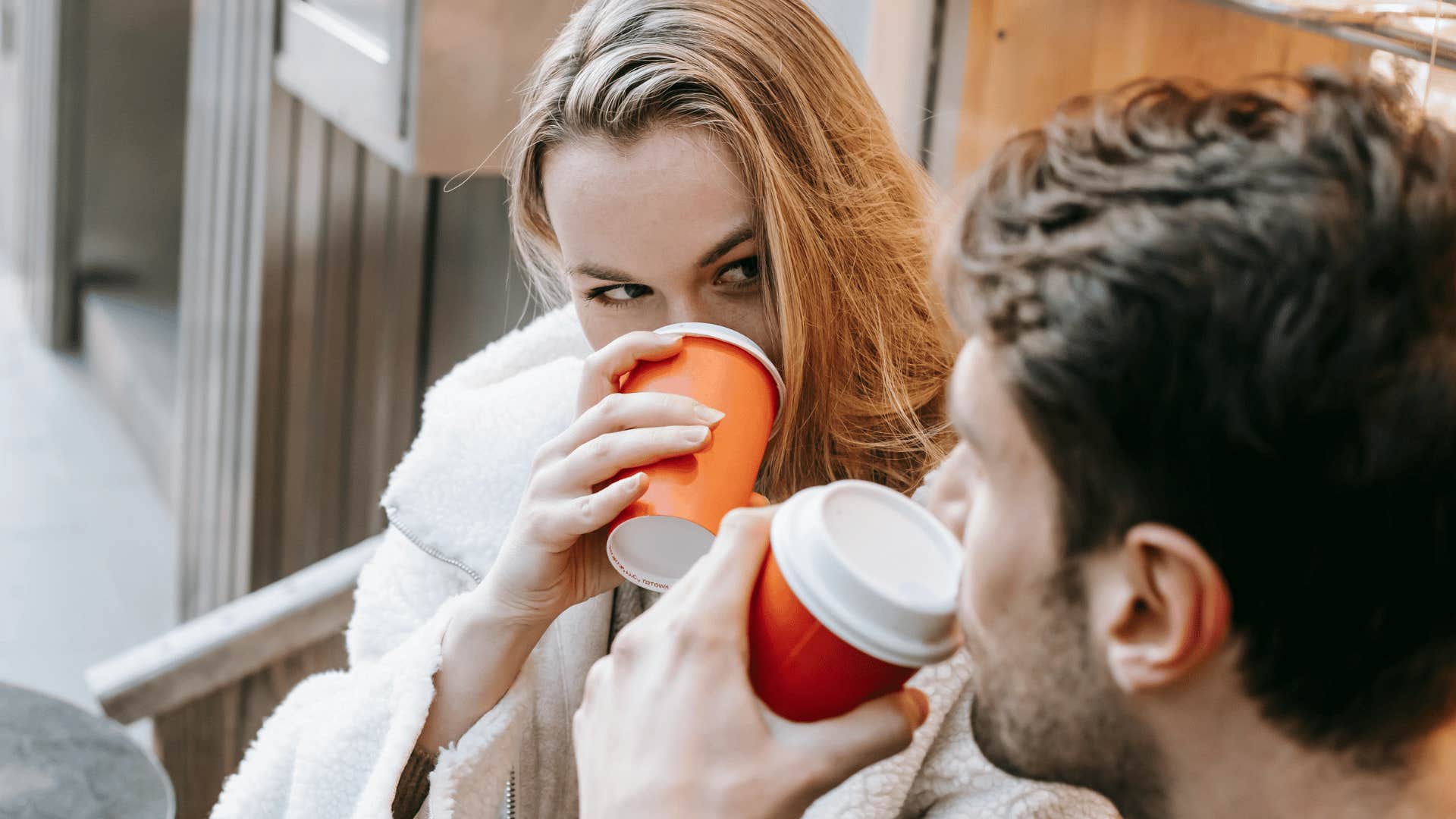 couple's eyes meeting while drinking coffee together