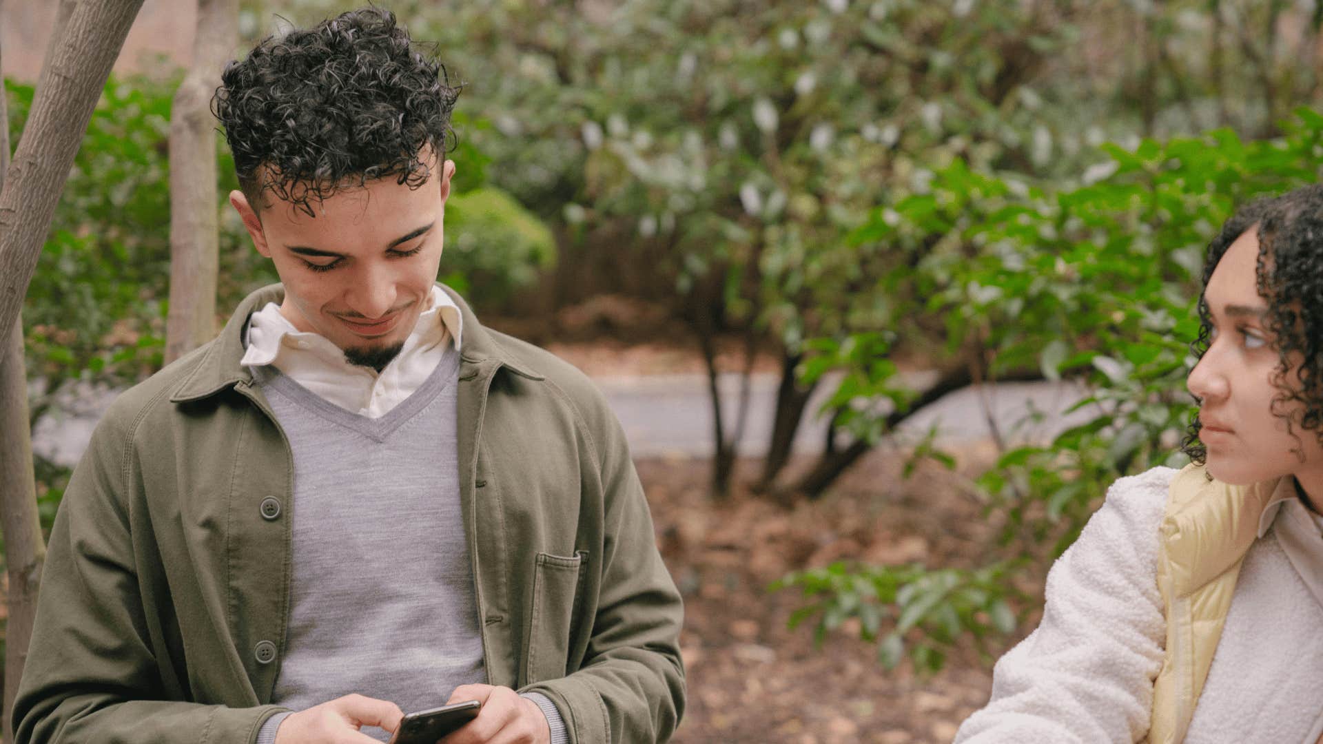 serious woman looking at man on phone