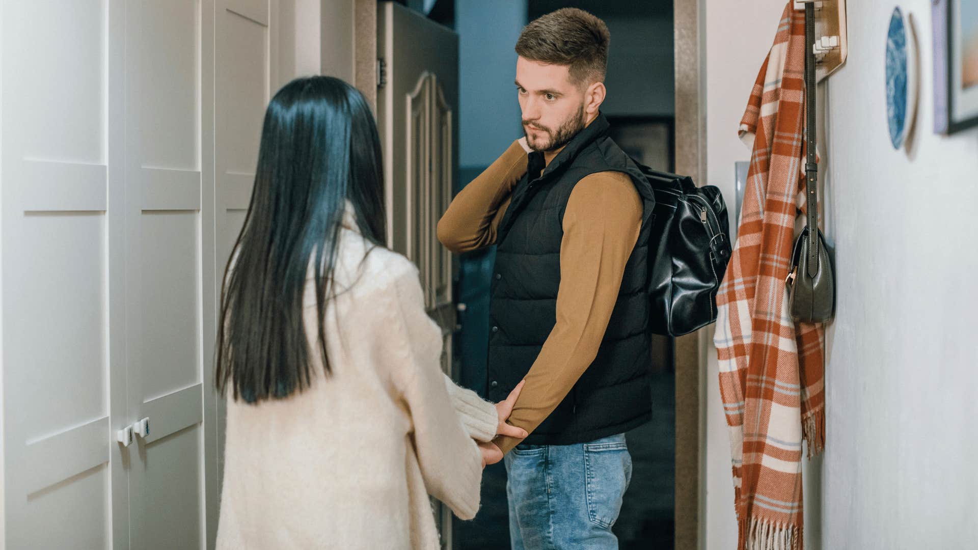 woman holding man's hand in doorway