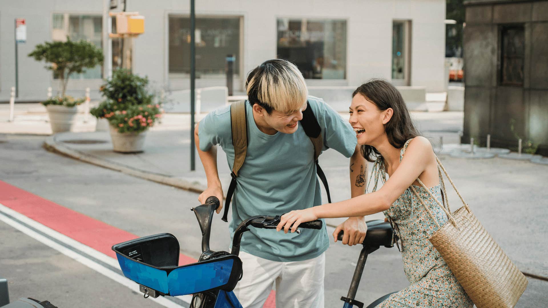 couple laughing and pushing bike together