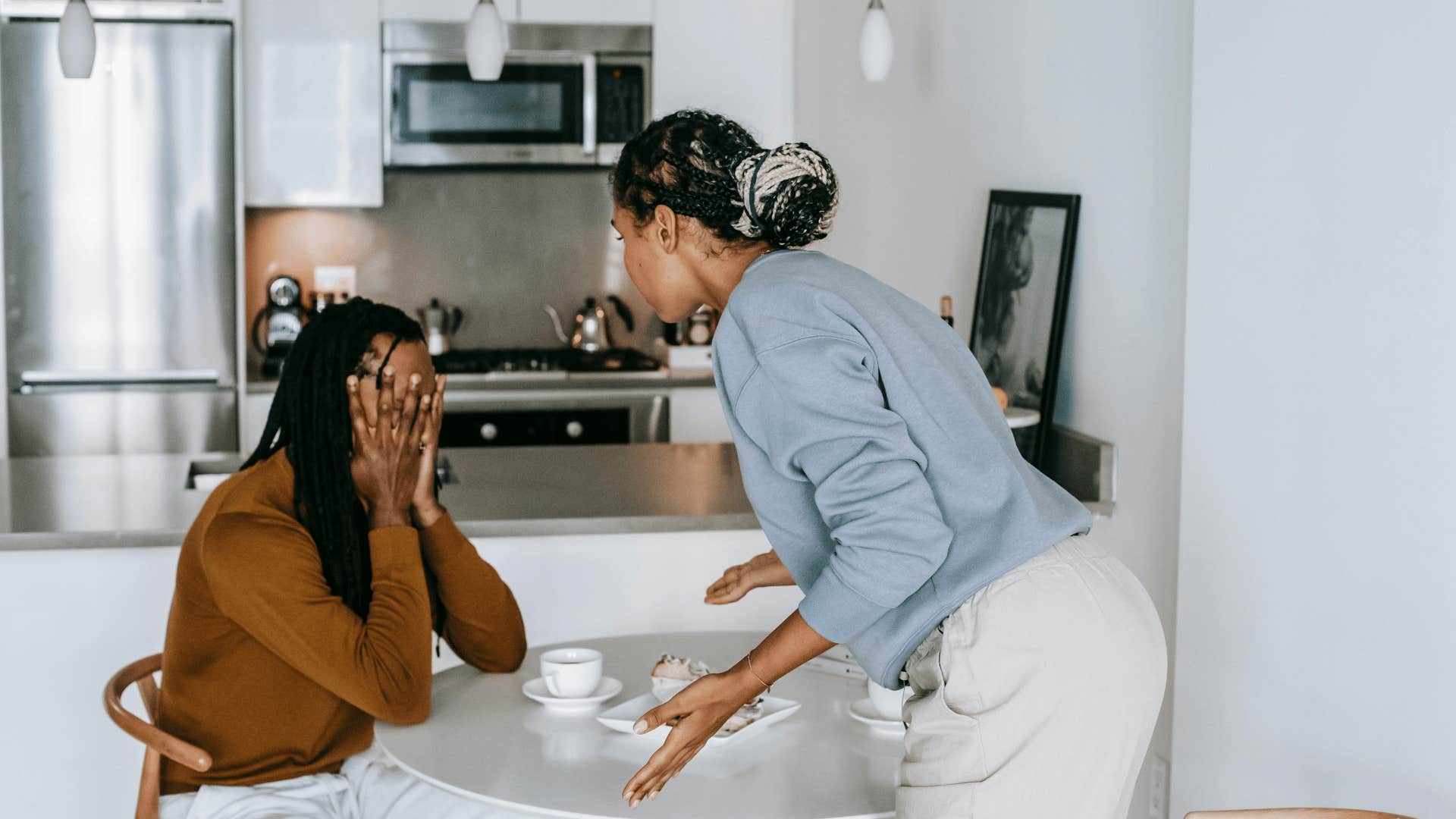 man covering face as woman is arguing