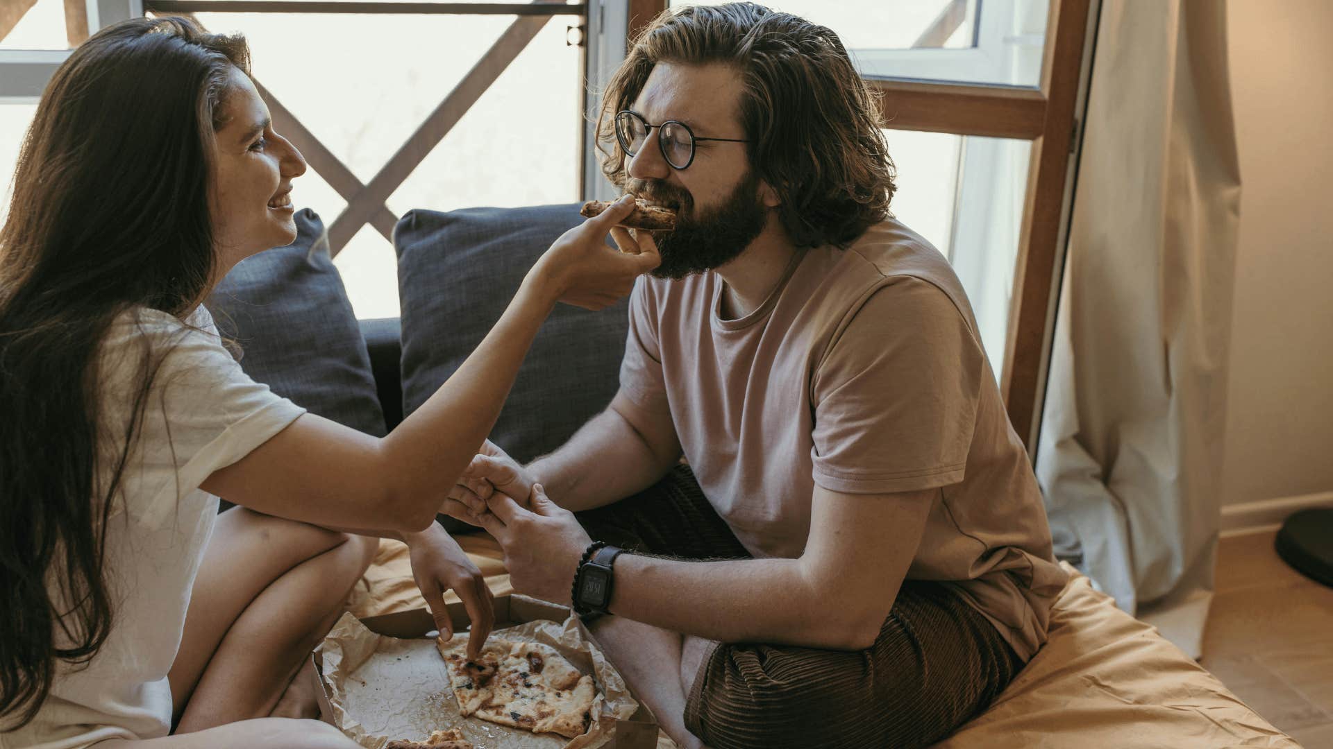 woman feeding man pizza