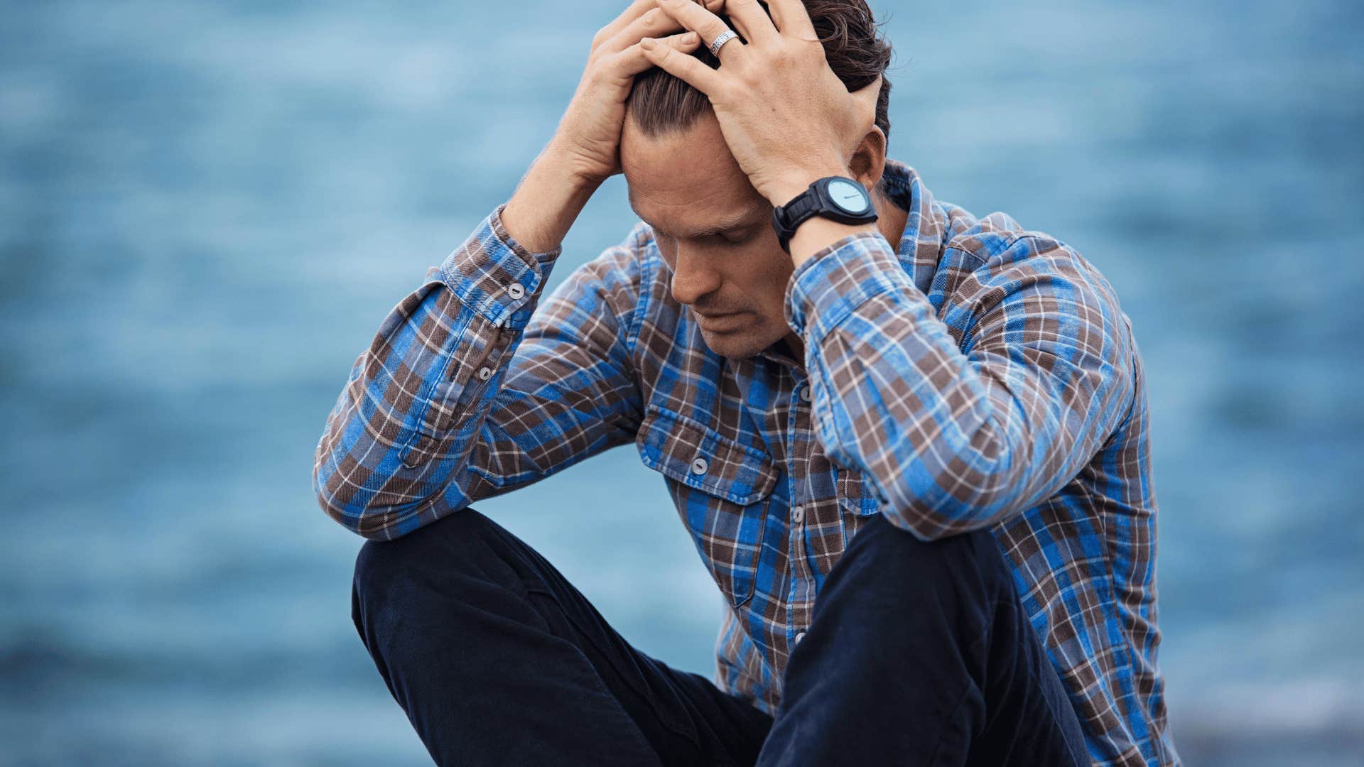 upset man holding head in hands