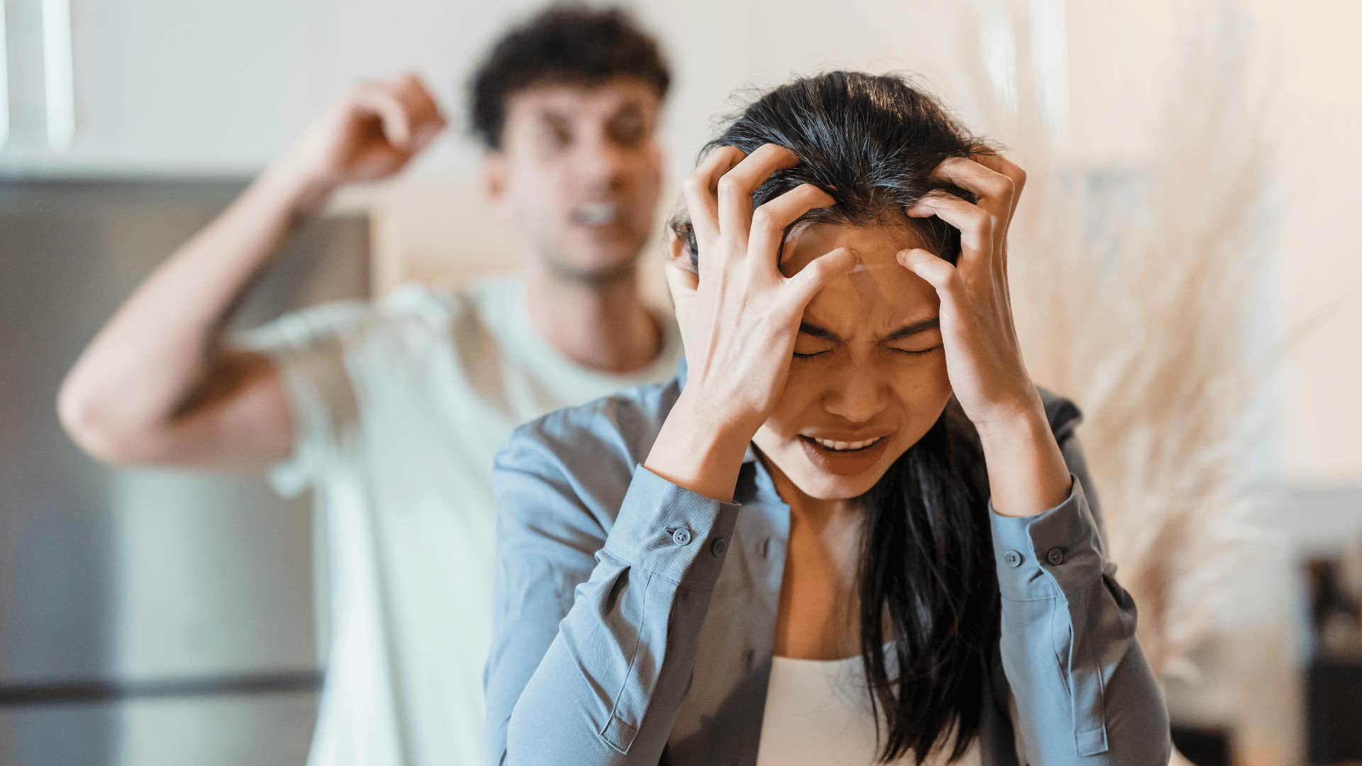 frustrated woman and blurred upset man yelling at her