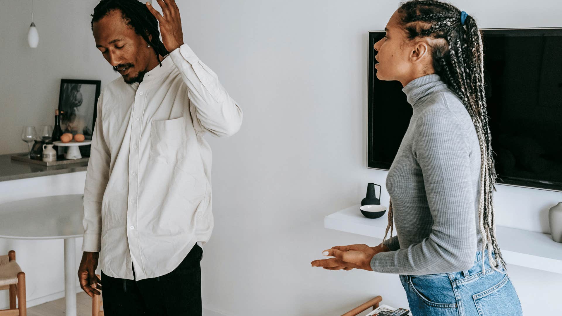 frustrated man turning away from upset woman