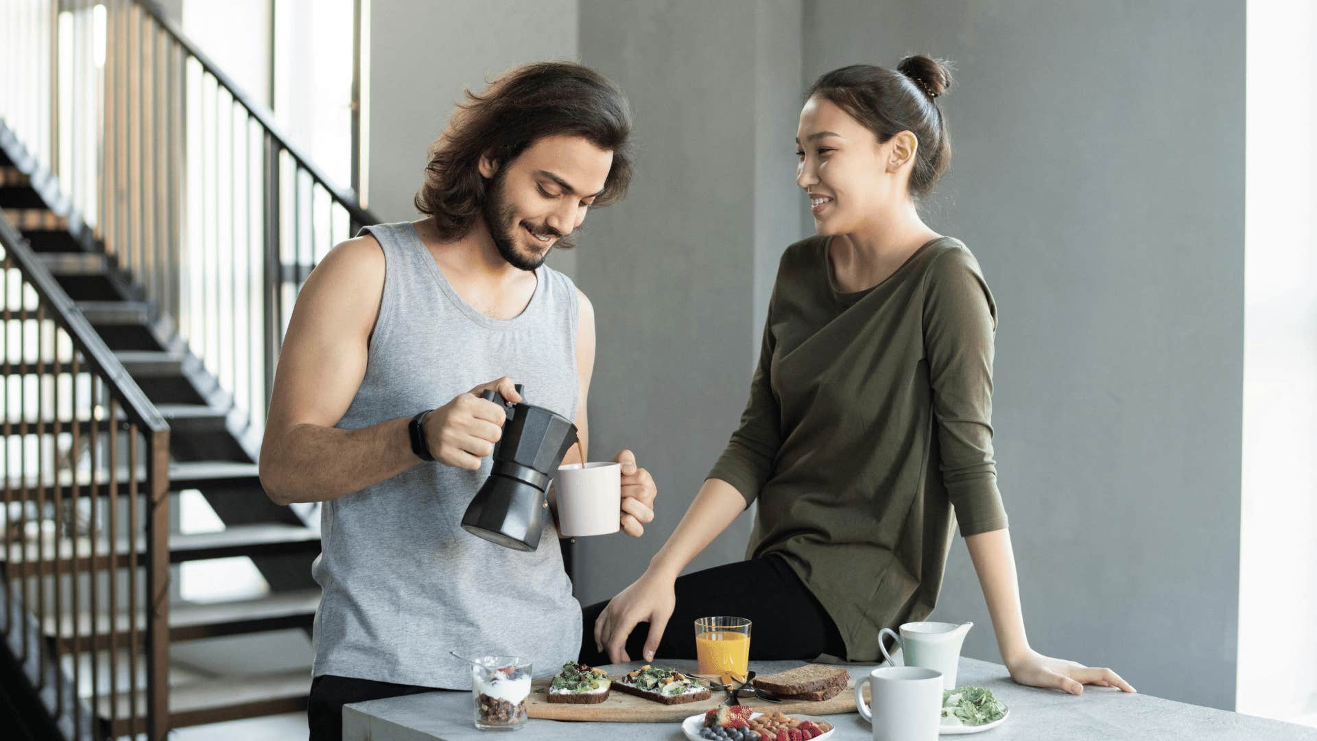 man pouring coffee and woman sitting on counter