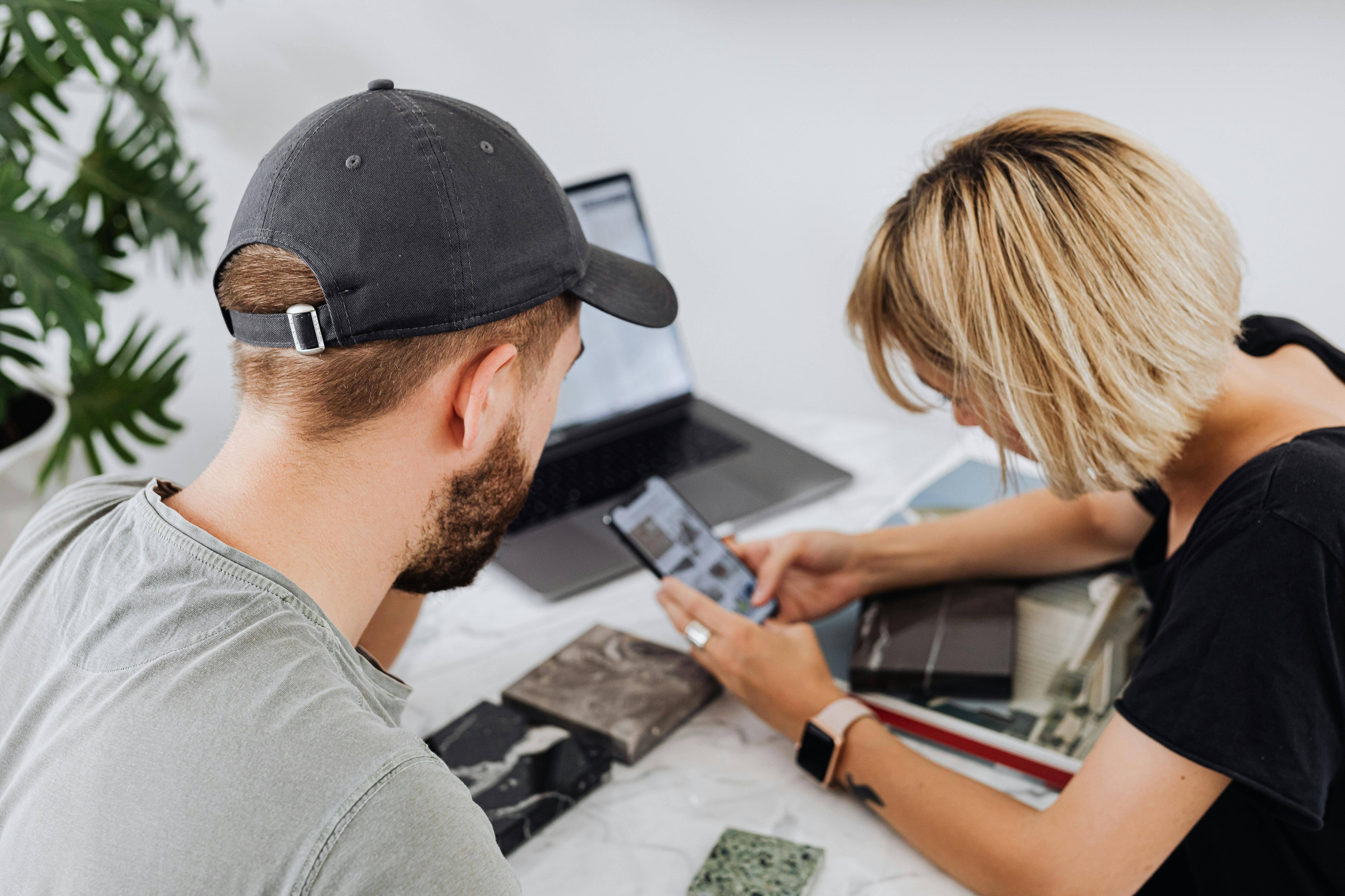 man looking over at woman on her phone