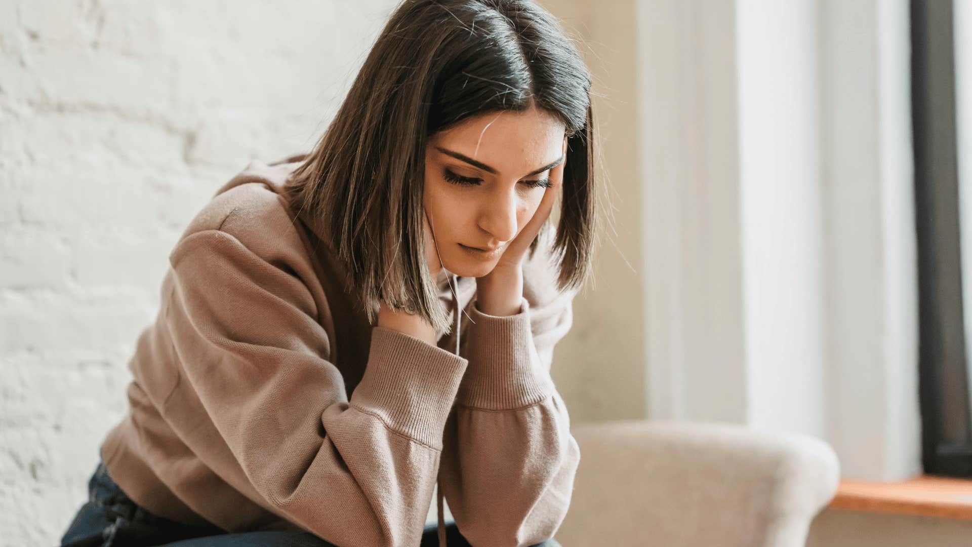 somber woman resting head on hands