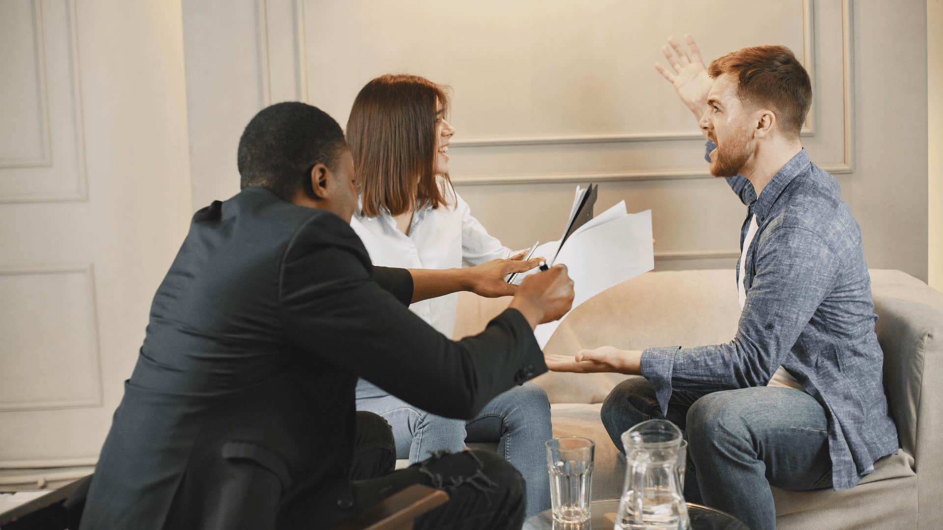 suited man breaking up arguing between couple