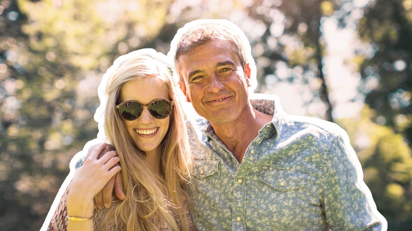 Couple wiht a wide age gap, outdoors in the trees, smiling pleasantly