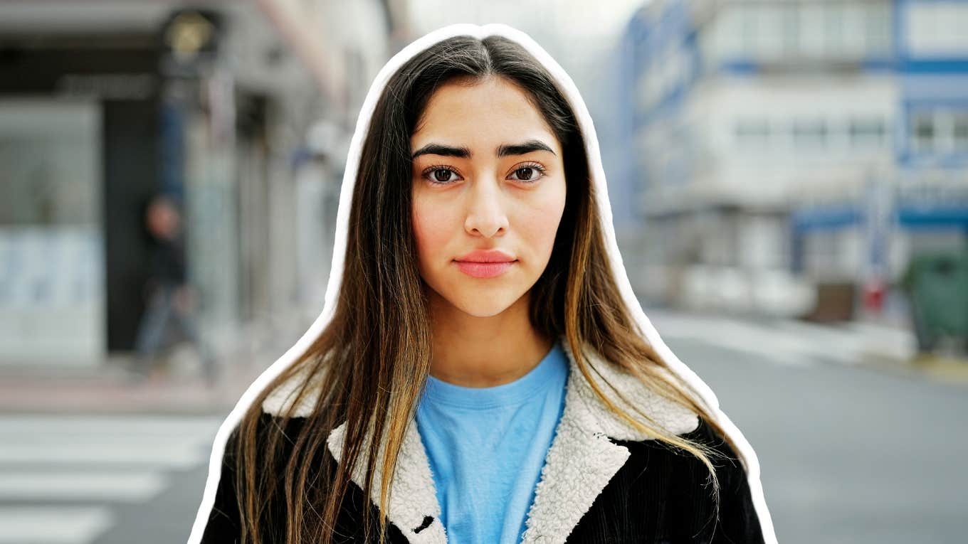 Young woman who grew up in chaos, calmly standing on a city street