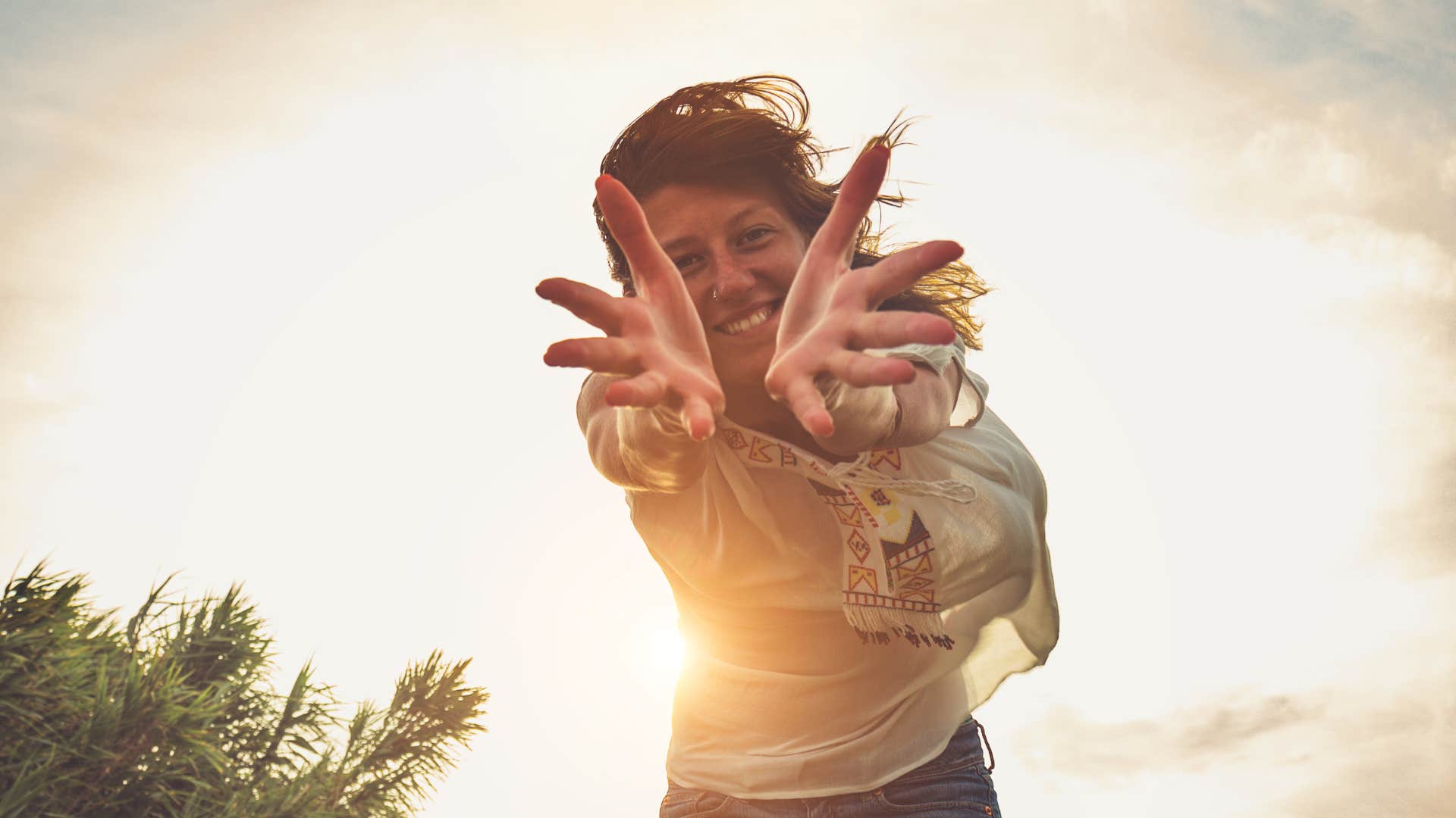 Woman backlit in sun, inviting in positivity 