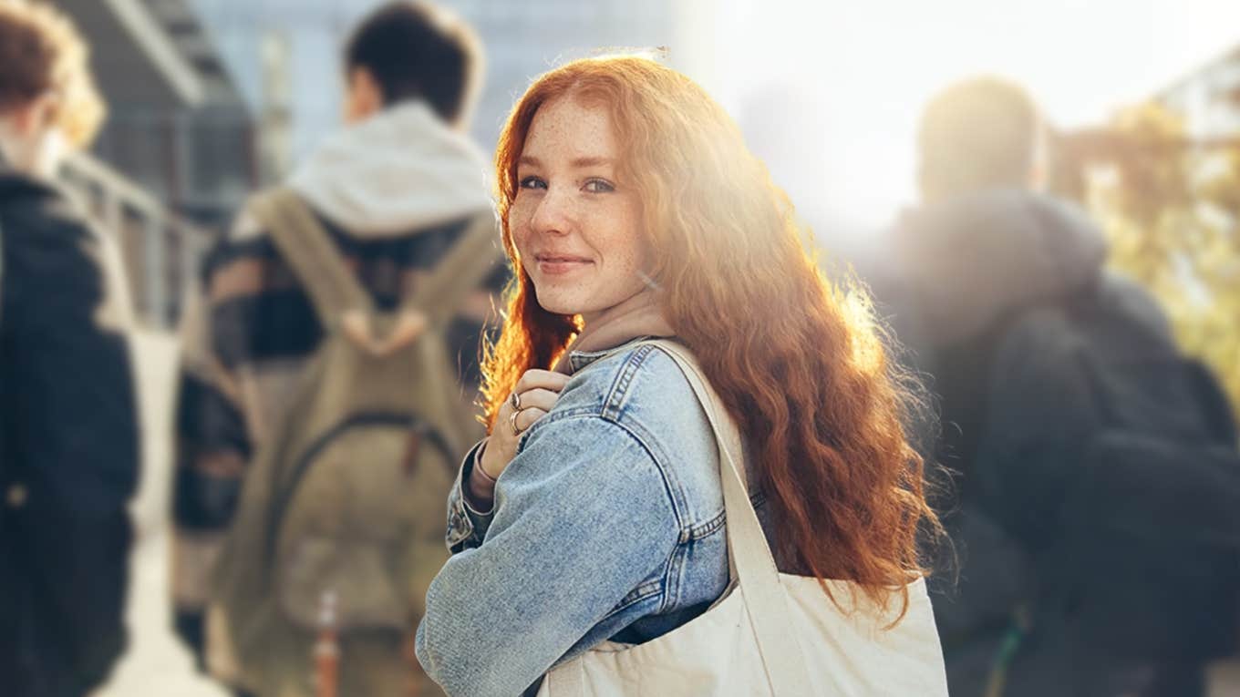 Redheaded teen girl looks at camera, not ready for college 