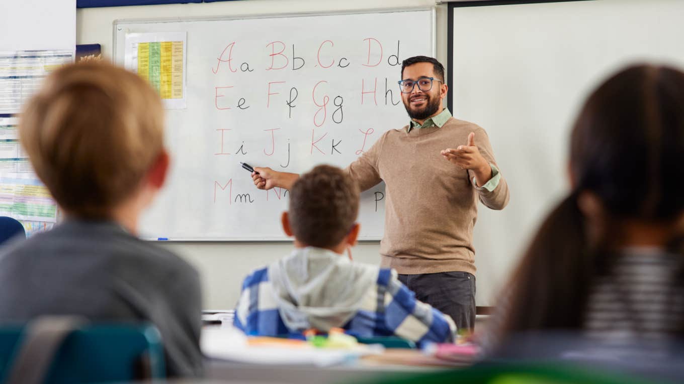 male teacher teaching students the alphabet in classroom