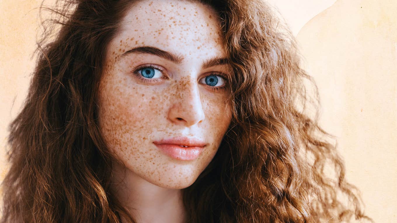 Woman with freckles trying on a new life