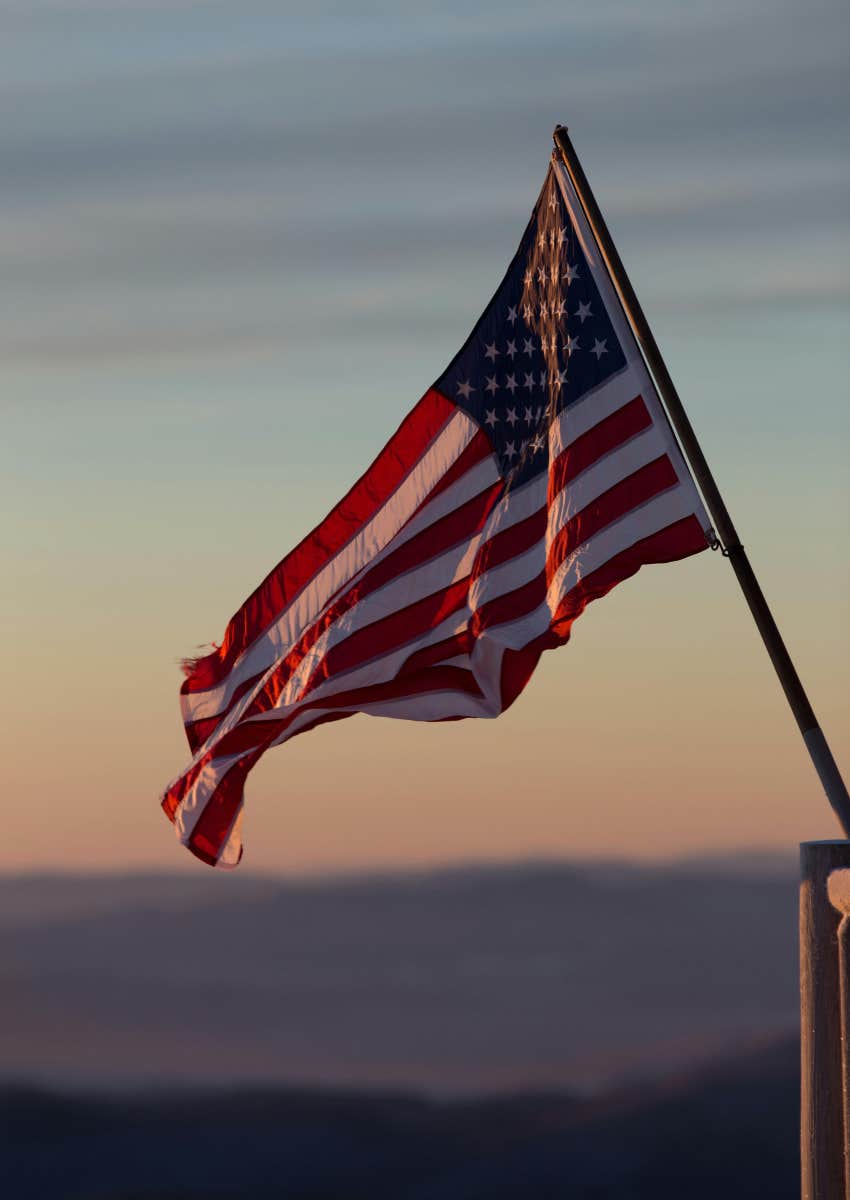 American flag waving in front of sunset