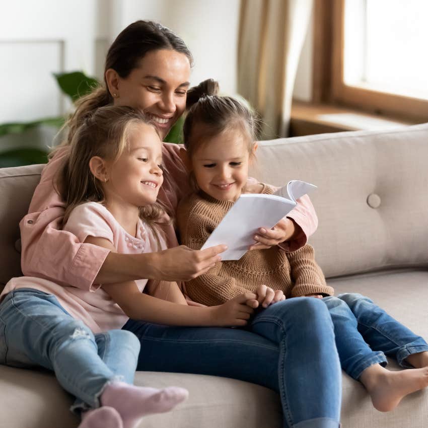 Babysitter reading to her client's kids at home.