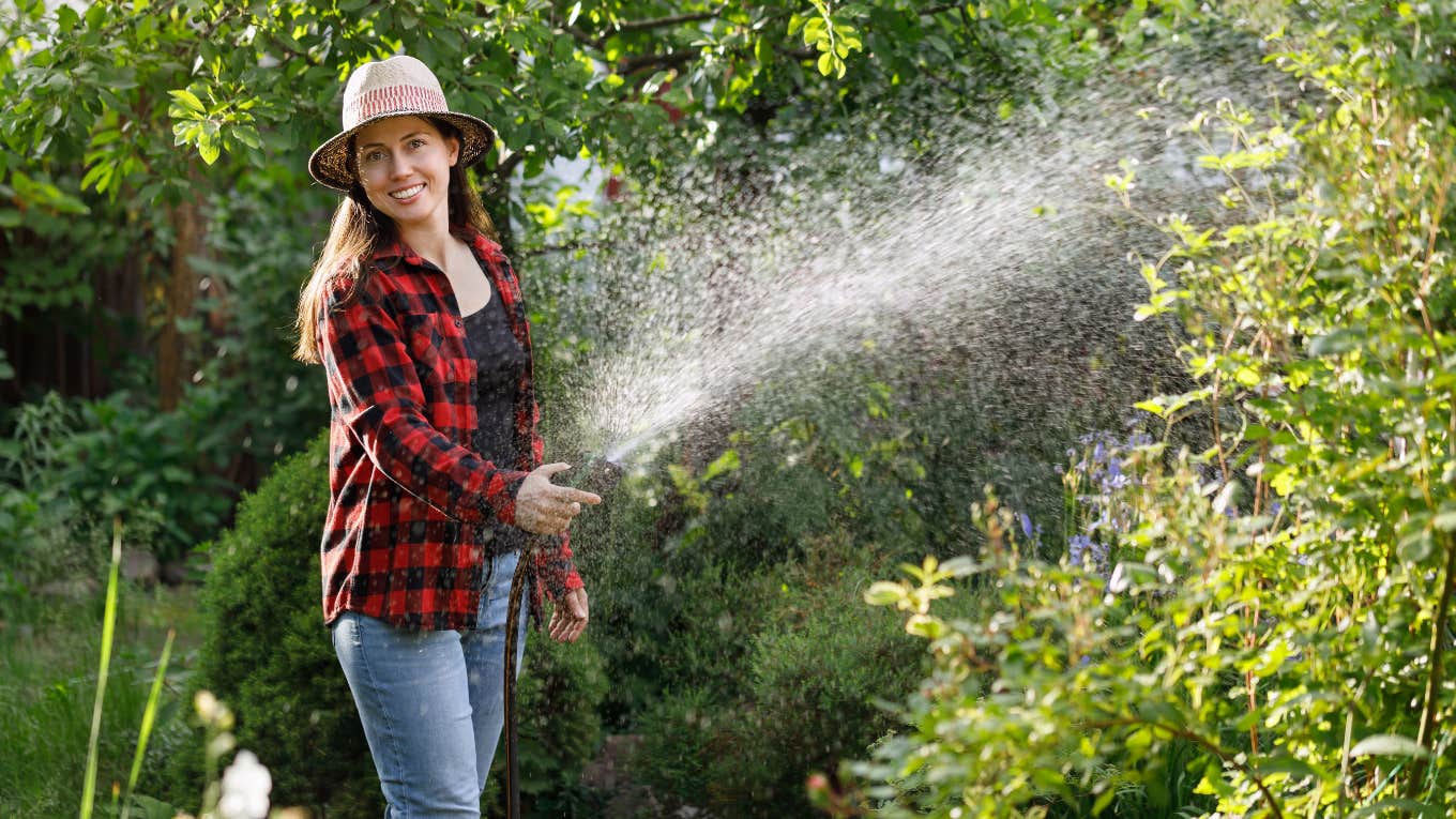 Young woman watering her garden