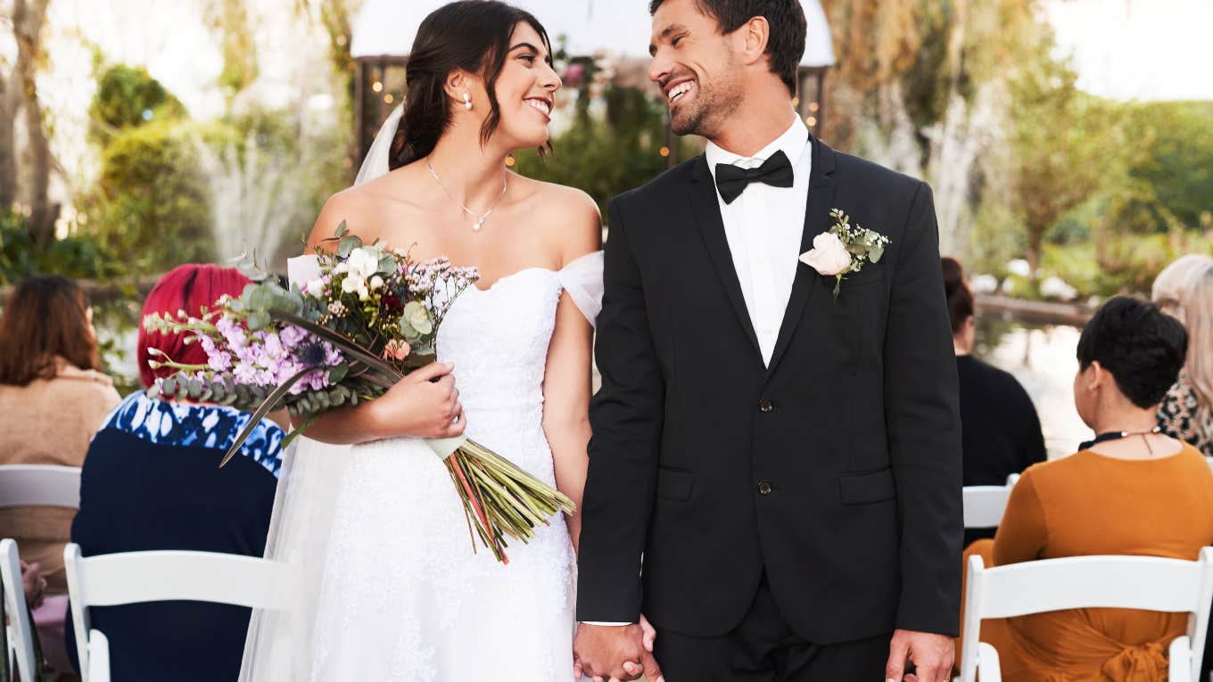 just married couple smiling at each other at the end of the aisle