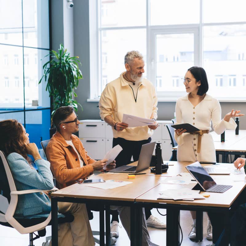 colleagues in casual clothes having meeting and discussing ideas while working together in modern office