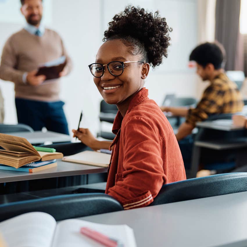 College student smiling in an in-state university classroom. 