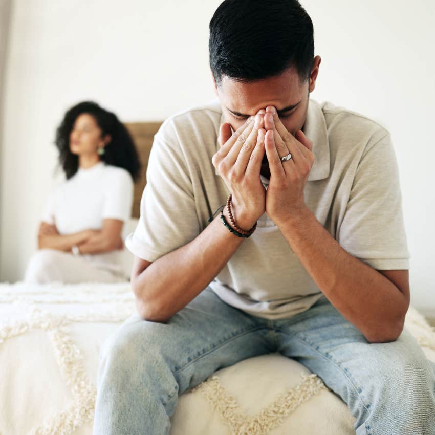 Man looking upset sitting in front of his girlfriend. 