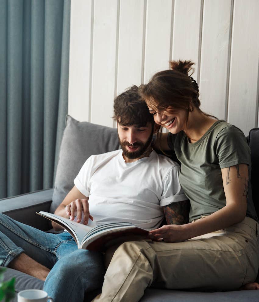 Couple on couch read together at the start of relationship 