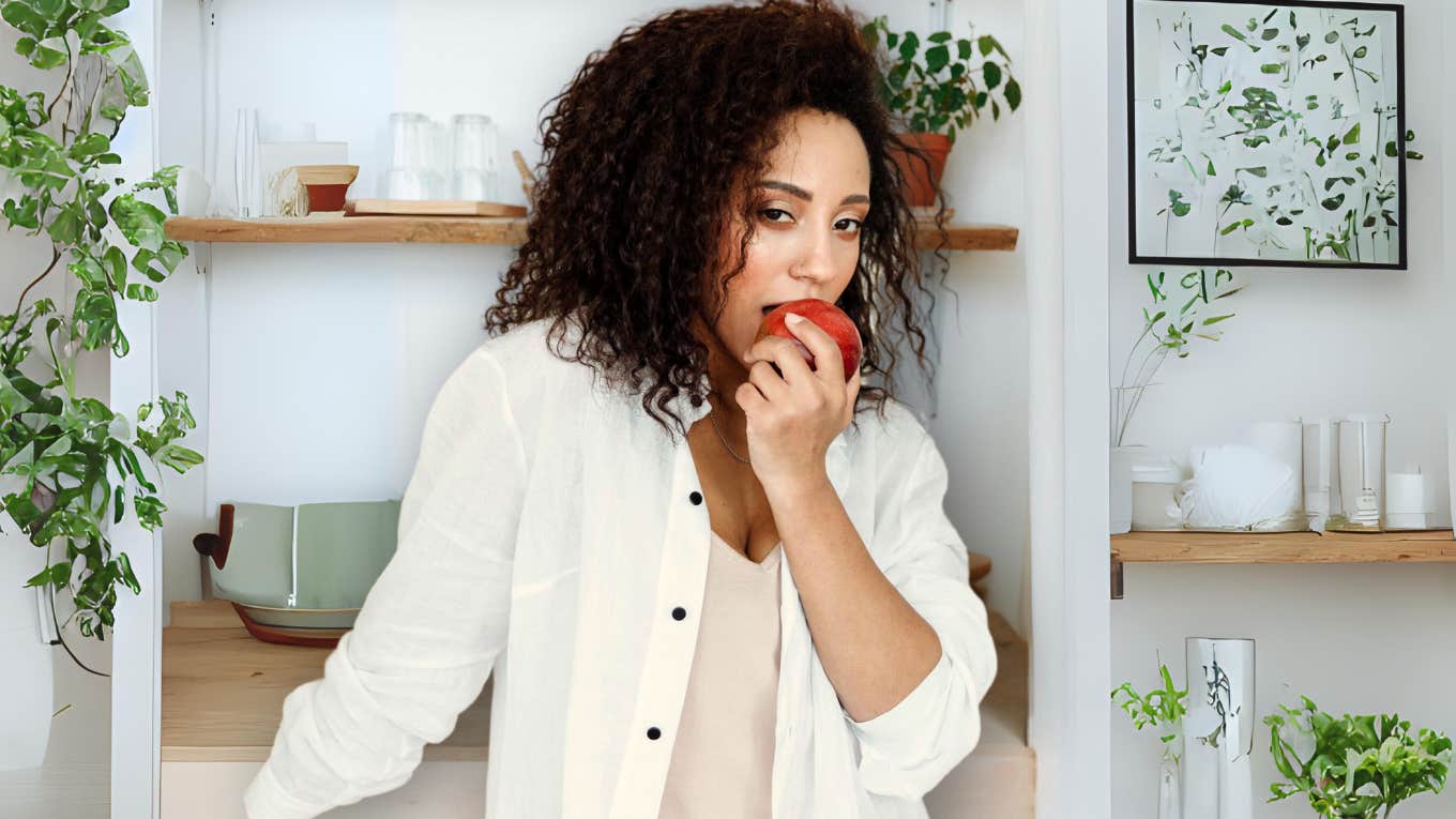 Confident healthy woman eating an apple