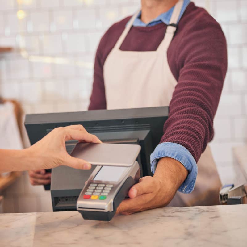 hands of customer paying with phone at cafe kiosk