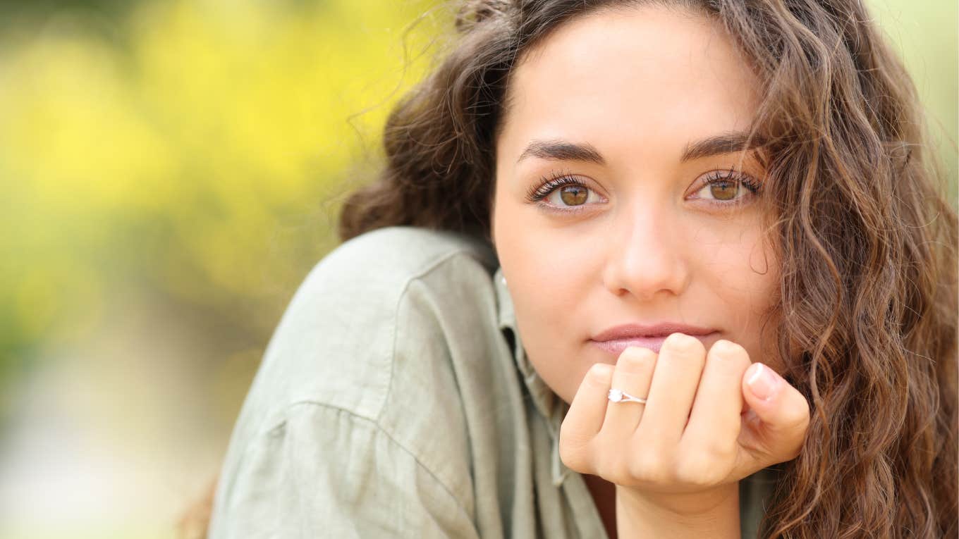 young woman with hand on chin wearing dainty purity ring