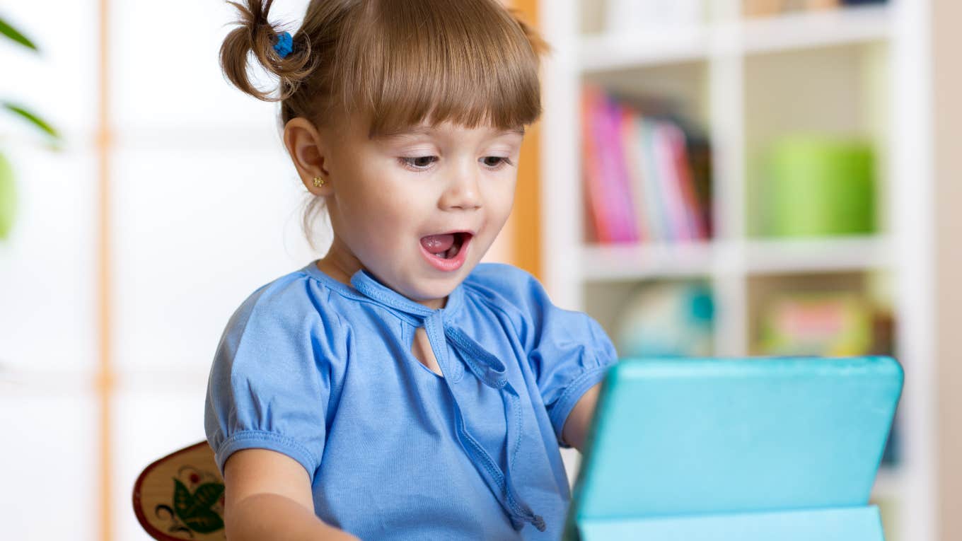 little girl looking happy using a tablet