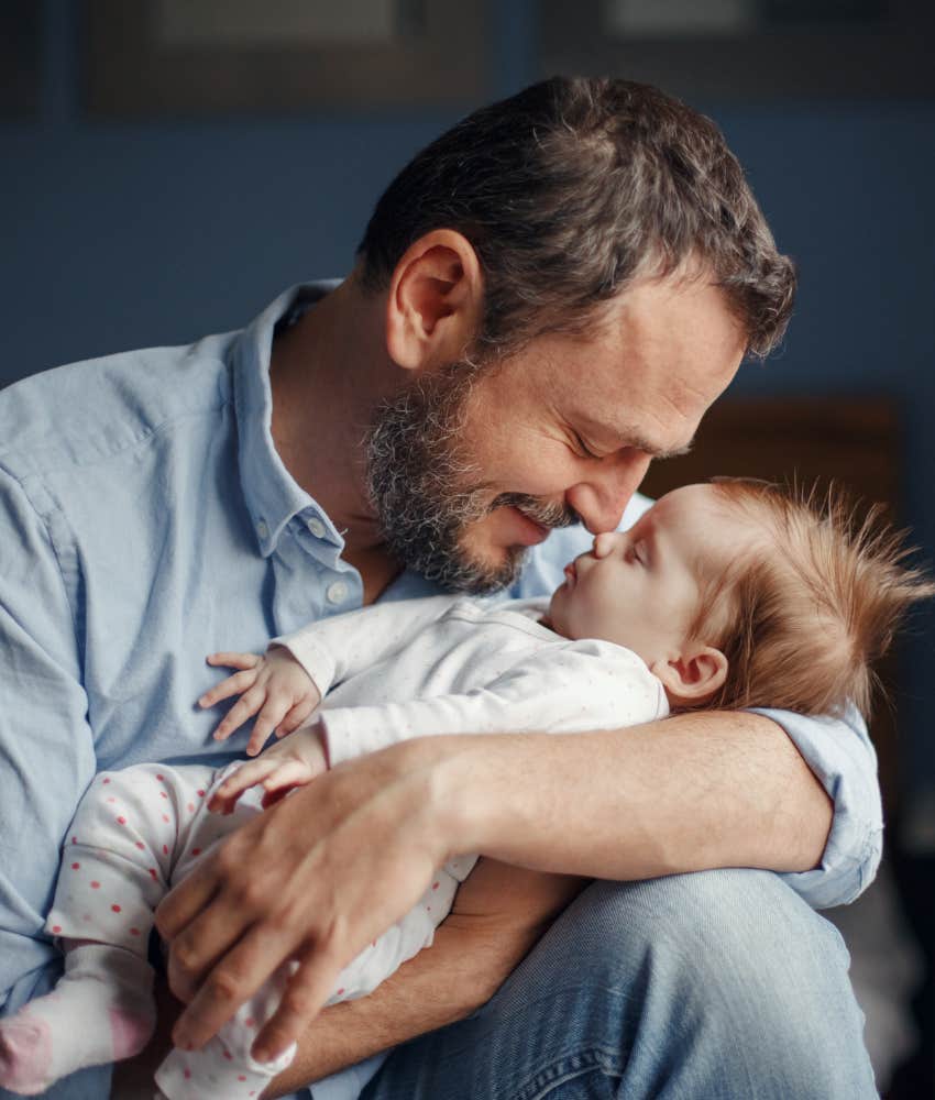 Dad snuggling his infant daughter