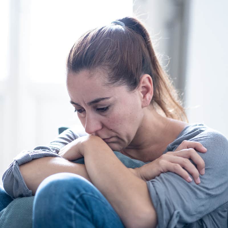 depressed woman sitting on sofa