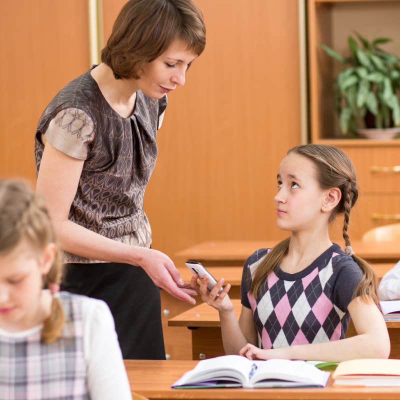 teacher taking student's phone away in class