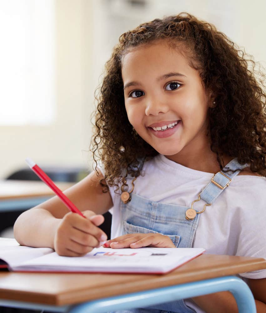 little girl coloring in classroom