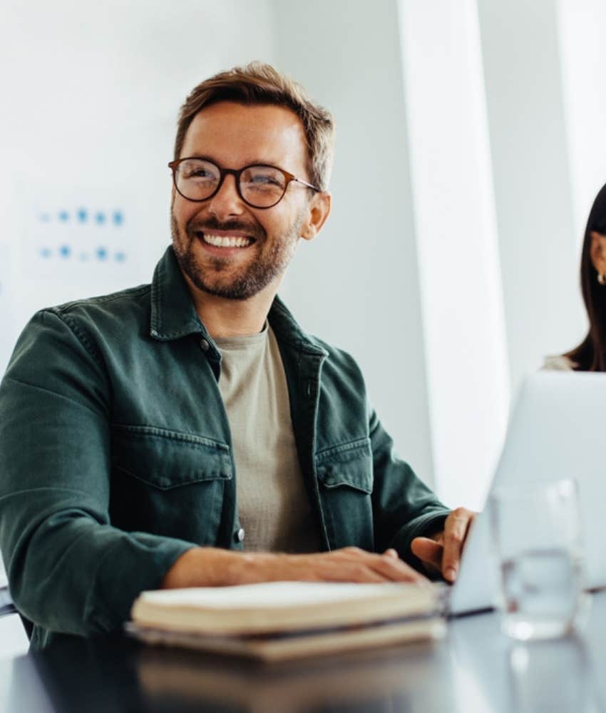 Employee wearing glasses and smiling at work