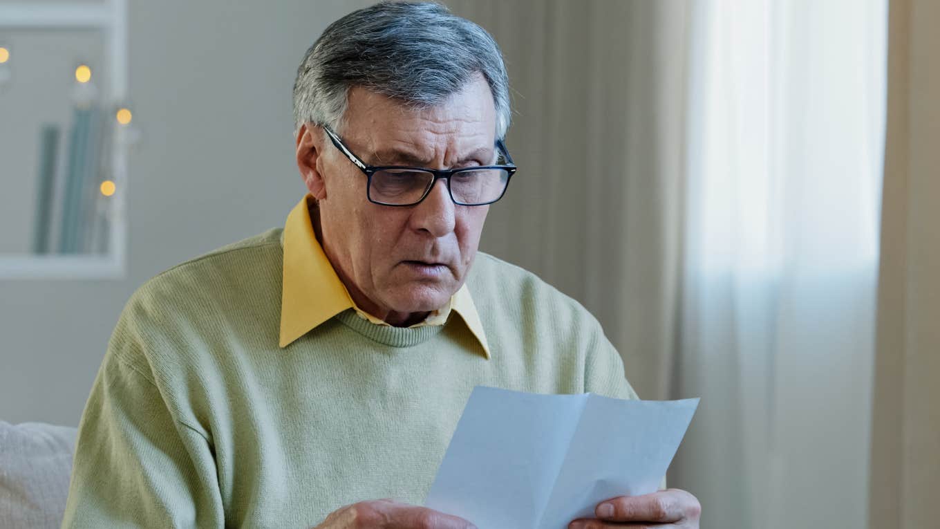 Worker reading a resignation letter looking upset. 