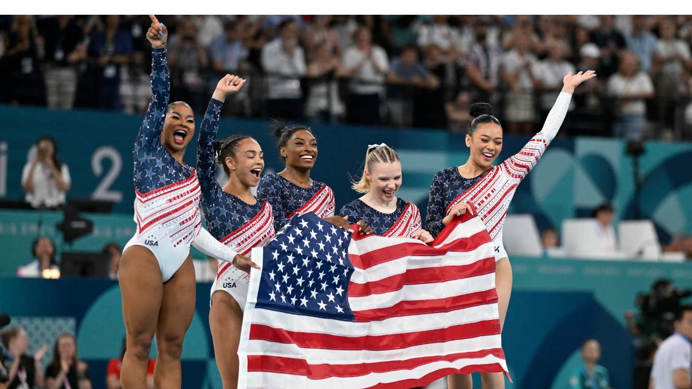 Team USA Gymnastics holding flag after winning gold medal