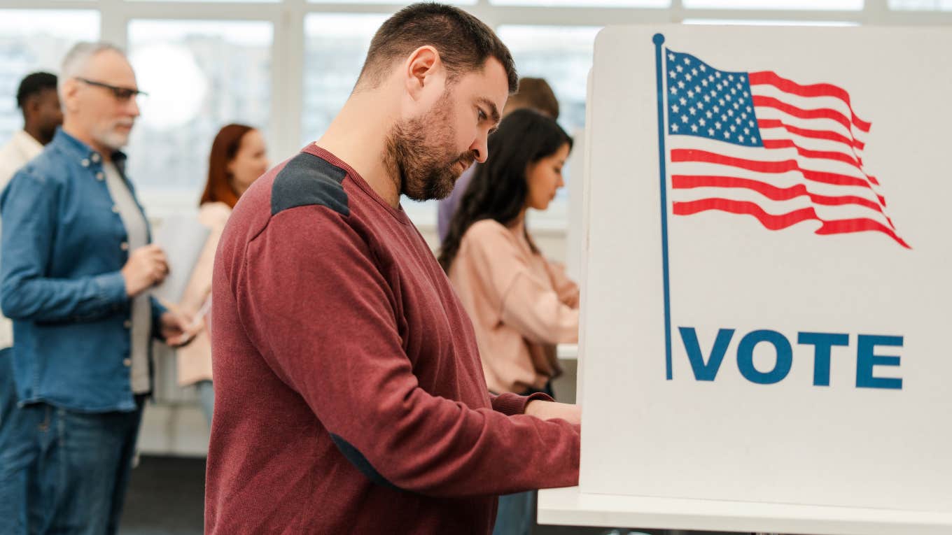 middle-aged man voting at booth