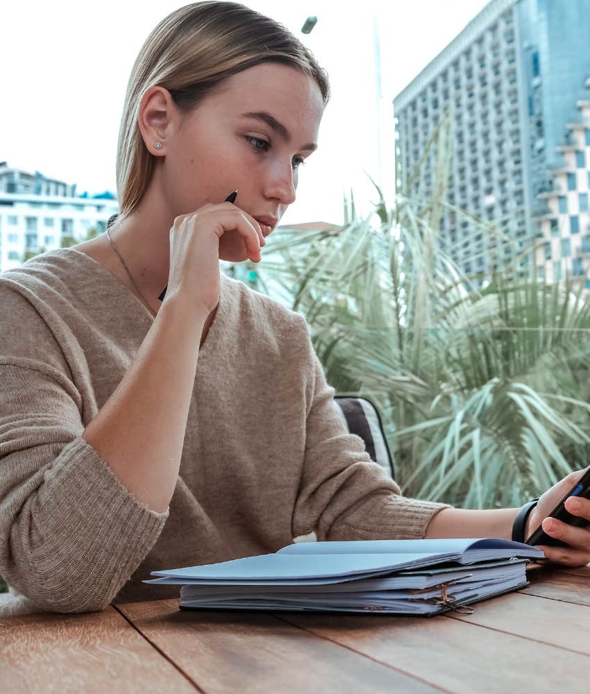 Gen Z woman looking at phone intently trying to figure out life