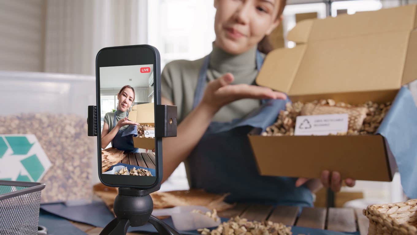 woman doing unboxing of package in front of camera for social media