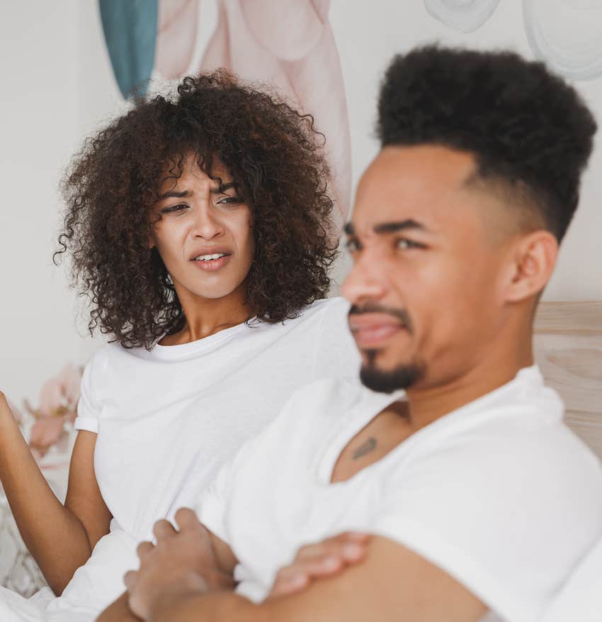 Woman talks to defensive man with crossed arms