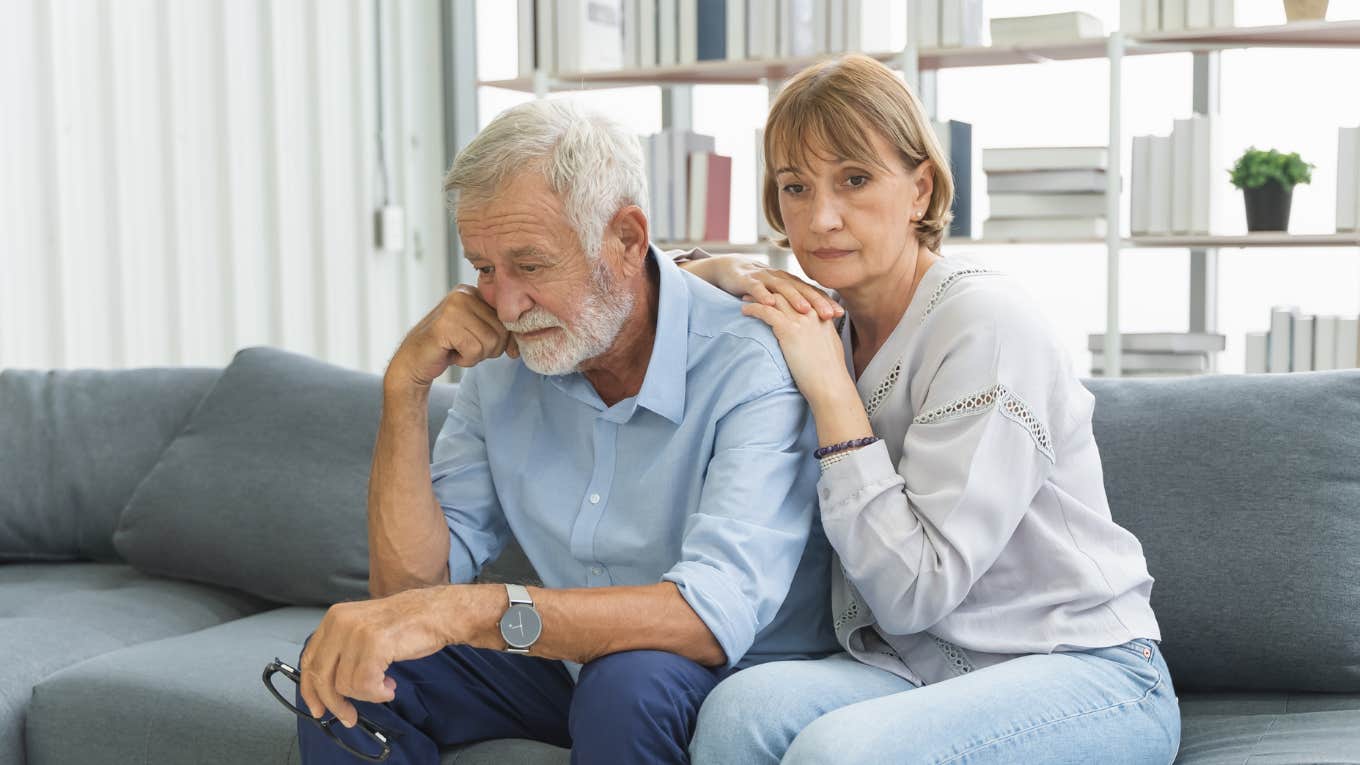 Sad grandparents sitting on a couch