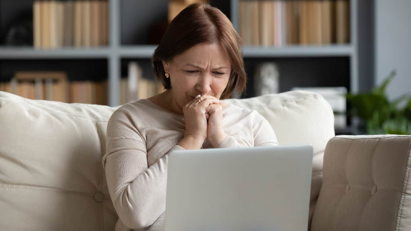 upset woman looking at the laptop in her lap